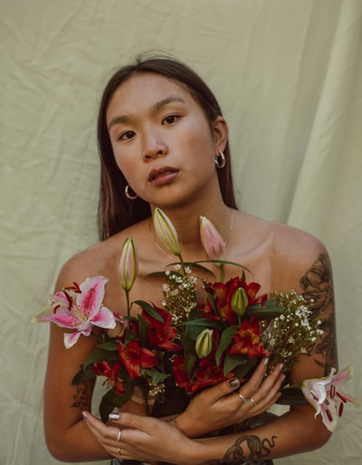 穿着白色花裙的女人，手里拿着一束花